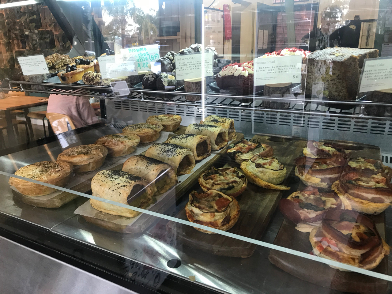 A cabinet filled with pies and sausage rolls